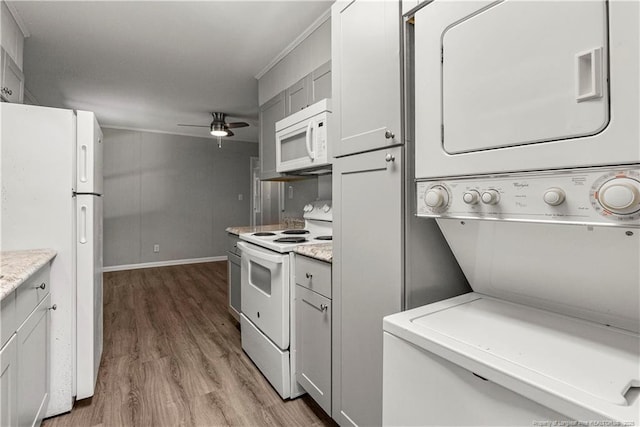 3518 Drayton Rd, Fayetteville, NC 28303 - kitchen with stacked washer and clothes dryer, wood finished floors, white appliances, light countertops, and ceiling fan