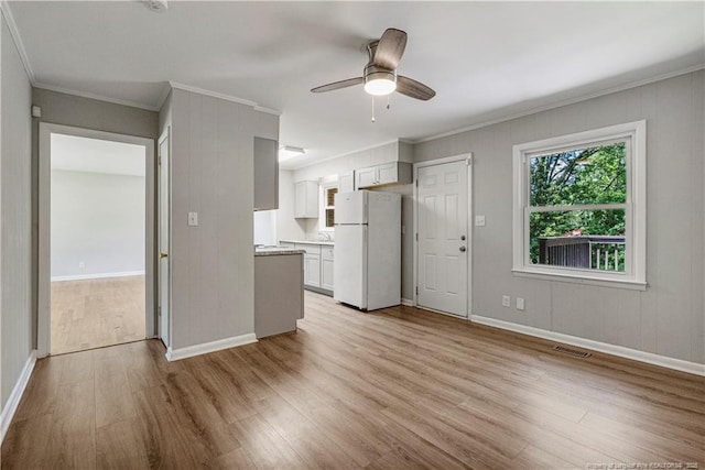 3518 Drayton Rd, Fayetteville, NC 28303 - unfurnished living room with visible vents, light wood-style flooring, a ceiling fan, ornamental molding, and baseboards