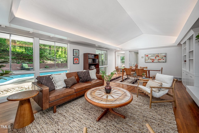 living room with visible vents, wood finished floors, and lofted ceiling