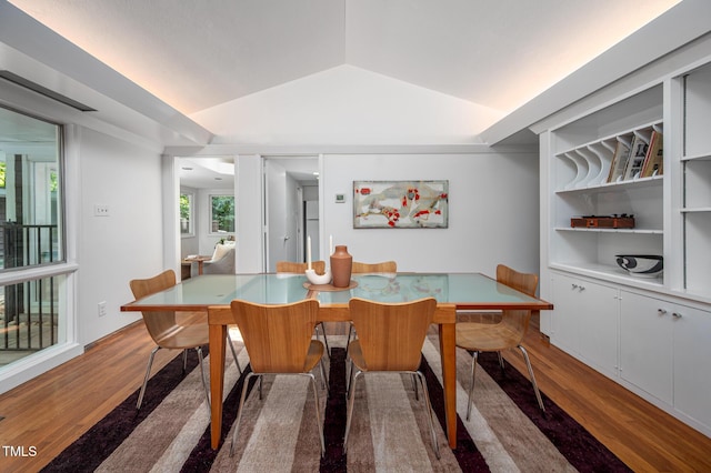 dining area with vaulted ceiling and wood finished floors