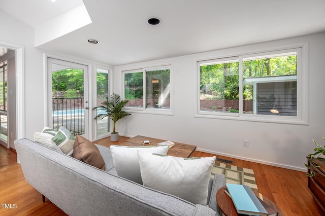 living room with plenty of natural light, baseboards, visible vents, and a skylight