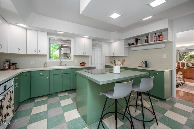 kitchen featuring a sink, light floors, white cabinets, and green cabinets