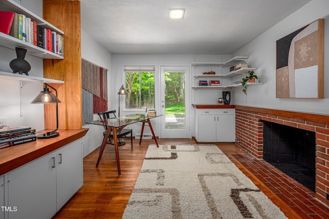 interior space featuring visible vents, a brick fireplace, and dark wood-style floors