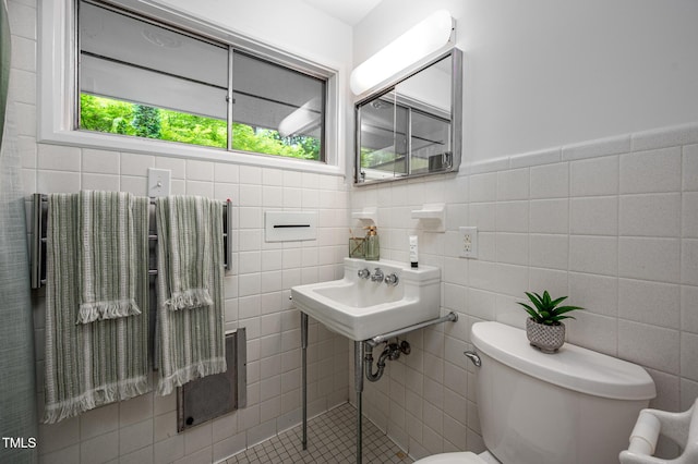 bathroom featuring toilet and tile walls