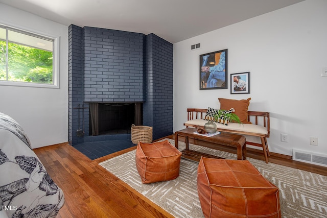 living room with visible vents, wood finished floors, and a fireplace