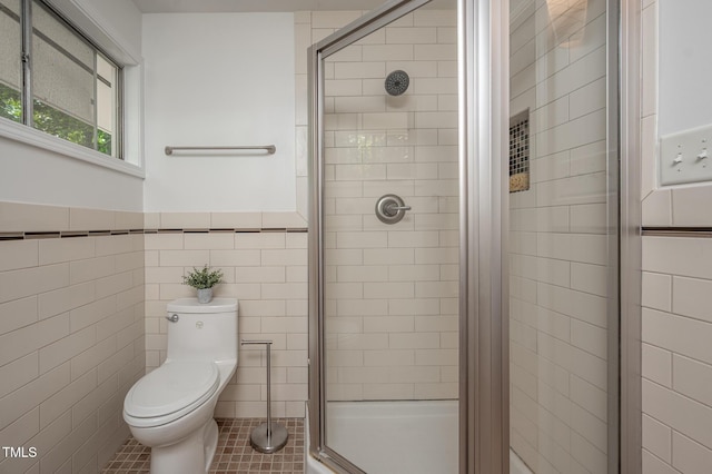 full bathroom featuring wainscoting, tile walls, a stall shower, and toilet