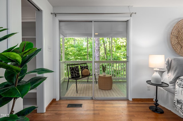 doorway to outside featuring visible vents, a wealth of natural light, and wood finished floors