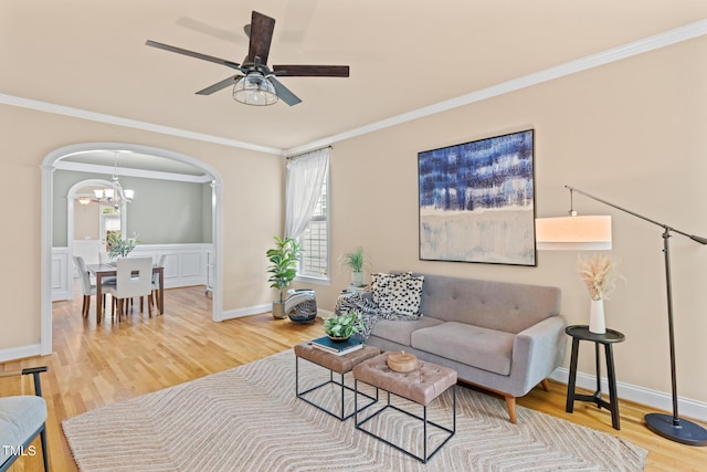 5233 Greymoss Ln, Apex, NC 27539 - living area featuring wood finished floors, arched walkways, plenty of natural light, a ceiling fan, and crown molding