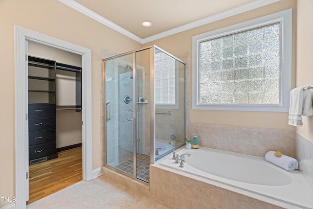 5233 Greymoss Ln, Apex, NC 27539 - bathroom featuring a bath, ornamental molding, a stall shower, a spacious closet, and baseboards