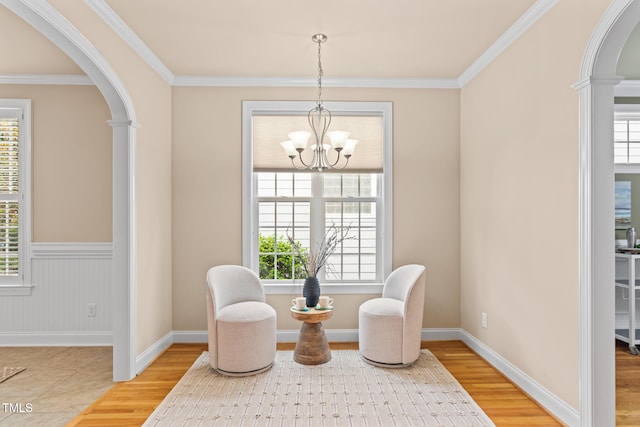 5233 Greymoss Ln, Apex, NC 27539 - sitting room featuring arched walkways, wood finished floors, a chandelier, ornamental molding, and a wainscoted wall