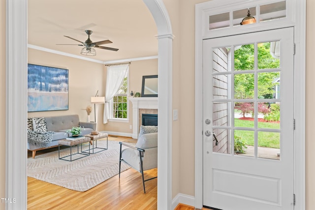5233 Greymoss Ln, Apex, NC 27539 - entryway featuring arched walkways, crown molding, wood finished floors, ceiling fan, and baseboards