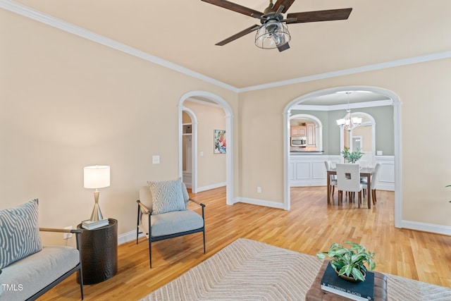 5233 Greymoss Ln, Apex, NC 27539 - living room with arched walkways, light wood-type flooring, ceiling fan, a chandelier, and baseboards
