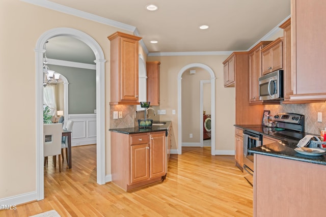 5233 Greymoss Ln, Apex, NC 27539 - kitchen featuring stainless steel appliances, arched walkways, a sink, light wood finished floors, and backsplash