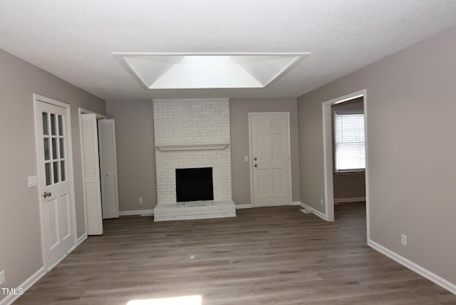 107 Ware Ct, Garner, NC 27529 - unfurnished living room with a textured ceiling, a fireplace, and wood finished floors