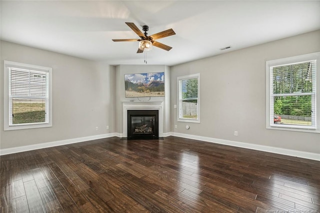 unfurnished living room featuring ceiling fan, plenty of natural light, a glass covered fireplace, and hardwood / wood-style floors