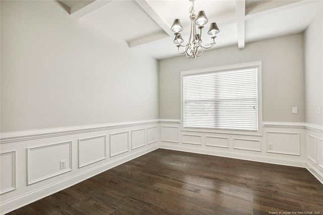 unfurnished dining area featuring a chandelier, beamed ceiling, coffered ceiling, a wainscoted wall, and dark wood-style floors