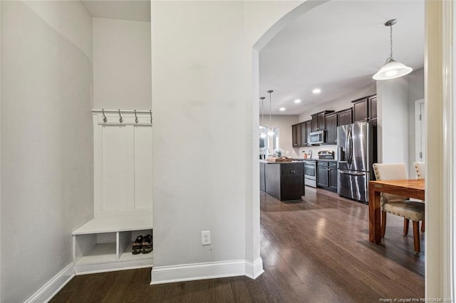 mudroom featuring arched walkways, dark wood-style flooring, baseboards, and recessed lighting