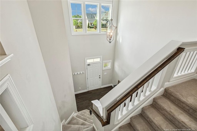 stairway with baseboards and a high ceiling