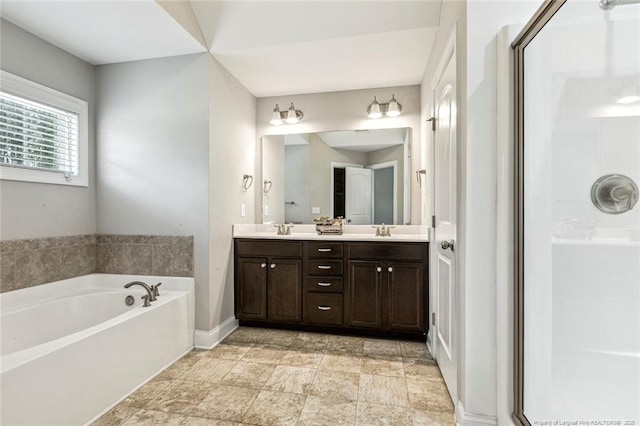 full bathroom with a garden tub, a stall shower, double vanity, and baseboards