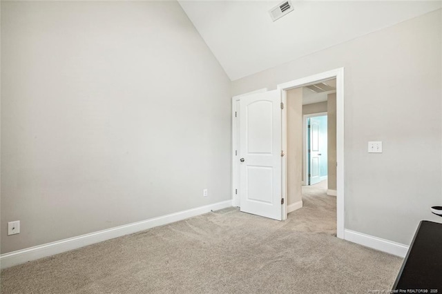 unfurnished room with light colored carpet, baseboards, and lofted ceiling