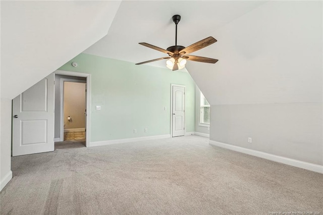 additional living space with carpet floors, baseboards, ceiling fan, and vaulted ceiling