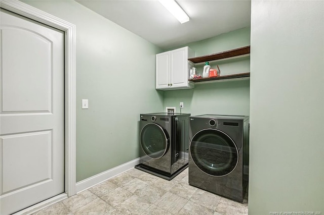 laundry room featuring washer and clothes dryer, cabinet space, and baseboards