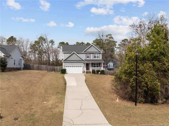 traditional-style home featuring concrete driveway, a porch, fence, and a front yard