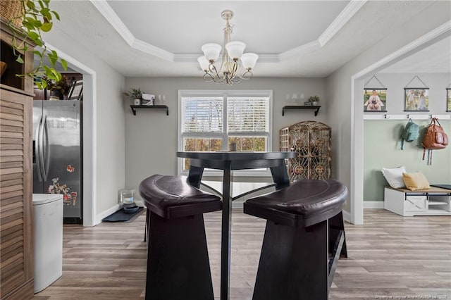 263 Autumn Ln, Raeford, NC 28376 - dining area with a raised ceiling, wood finished floors, a chandelier, baseboards, and crown molding
