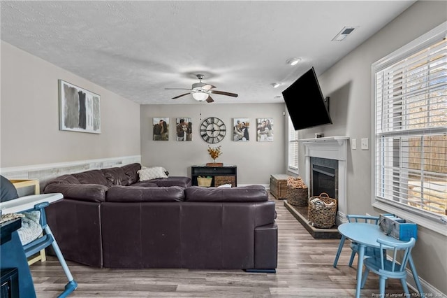 263 Autumn Ln, Raeford, NC 28376 - living area with a fireplace with raised hearth, a ceiling fan, healthy amount of natural light, and light wood finished floors