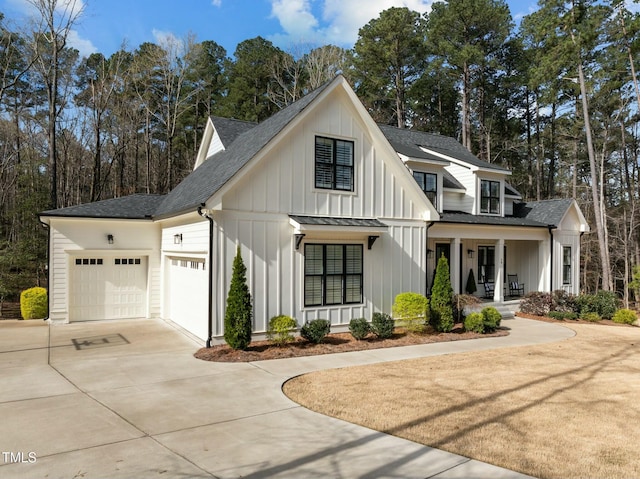76 Gentry Dr, Pittsboro, NC 27312 - modern farmhouse featuring board and batten siding, driveway, a porch, a garage, and a shingled roof