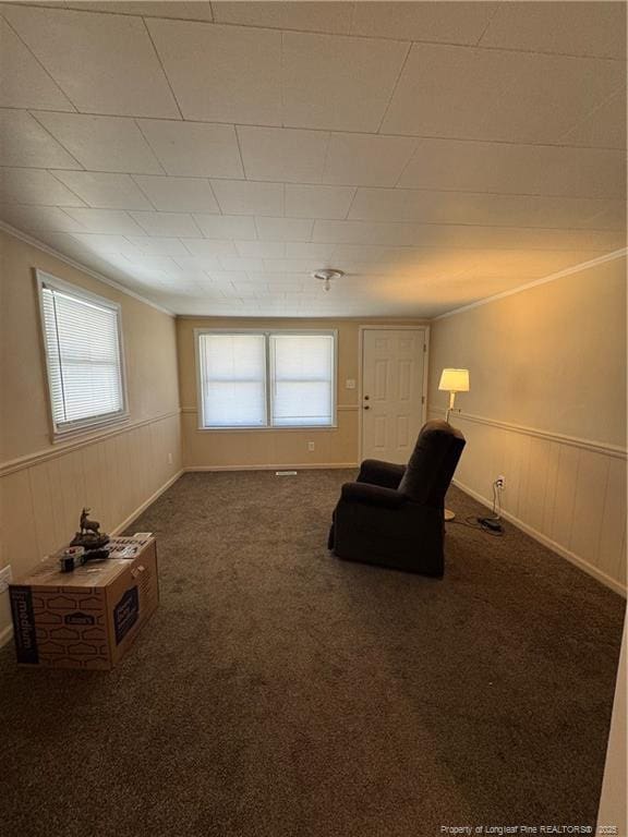 2907 George Owen Rd, Fayetteville, NC 28306 - unfurnished room with wooden walls, ornamental molding, dark colored carpet, and wainscoting