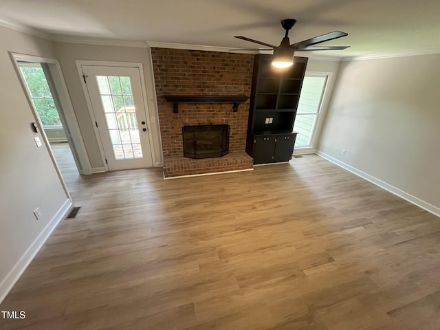 1116 Shadywood Ln, Raleigh, NC 27603 - unfurnished living room featuring a ceiling fan, a brick fireplace, baseboards, wood finished floors, and ornamental molding
