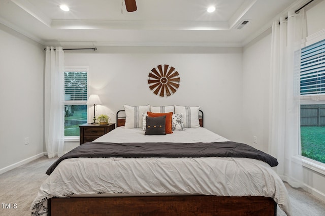 bedroom with a raised ceiling, light carpet, multiple windows, recessed lighting, and crown molding
