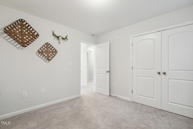 unfurnished bedroom with carpet floors, a closet, and baseboards