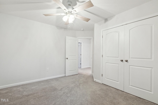 unfurnished bedroom with carpet, a closet, baseboards, and a ceiling fan