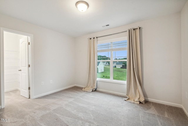 carpeted empty room featuring baseboards