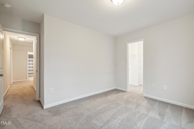 unfurnished bedroom with carpet flooring, attic access, and baseboards