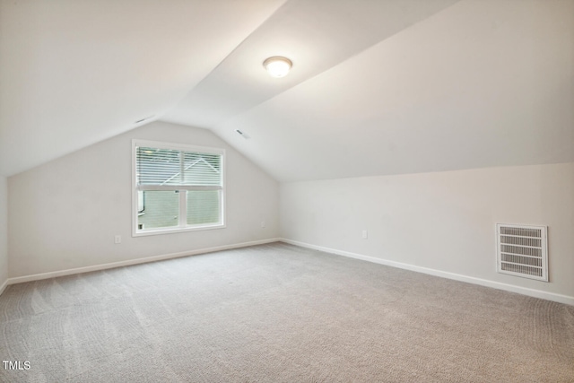additional living space with carpet floors, baseboards, and vaulted ceiling