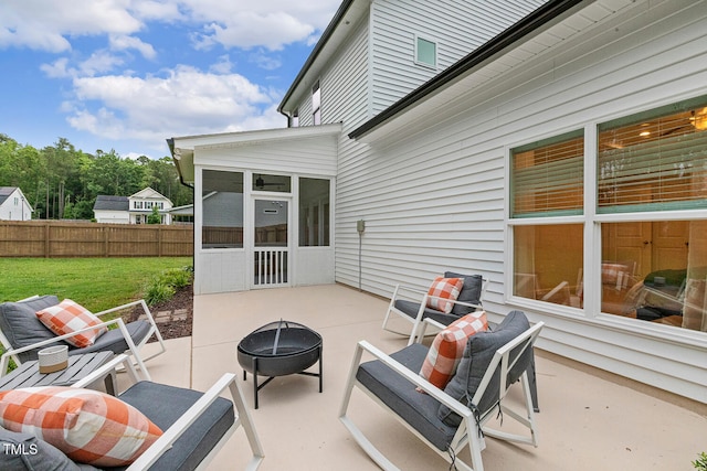 view of patio / terrace featuring a sunroom and an outdoor fire pit