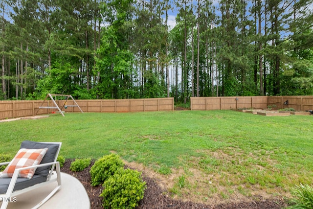 view of yard with a playground, a garden, and view of scattered trees