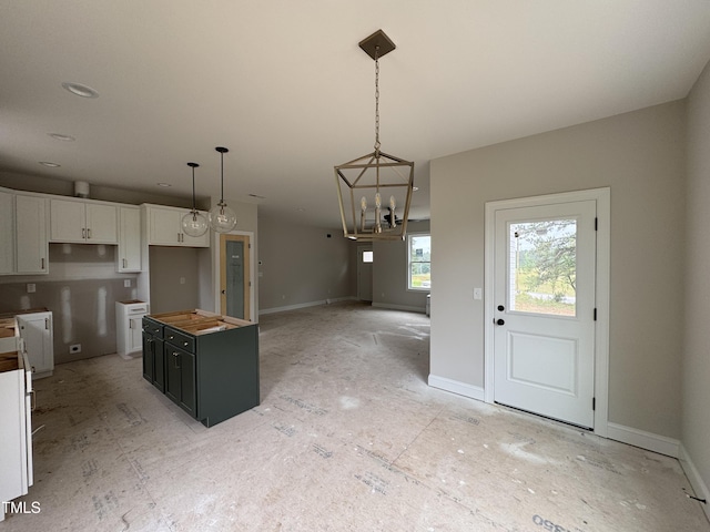 9600 Stallings Rd, Spring Hope, NC 27882 - kitchen with white cabinets, a center island, a chandelier, decorative light fixtures, and baseboards