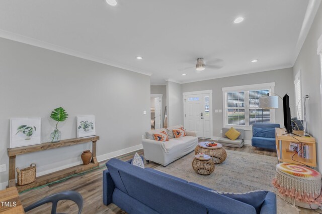 living room with ornamental molding, a ceiling fan, recessed lighting, wood finished floors, and baseboards
