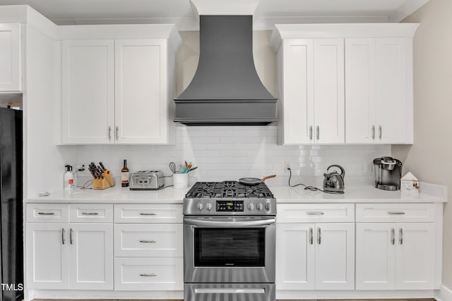 kitchen with white cabinets, premium range hood, light countertops, and stainless steel gas stove