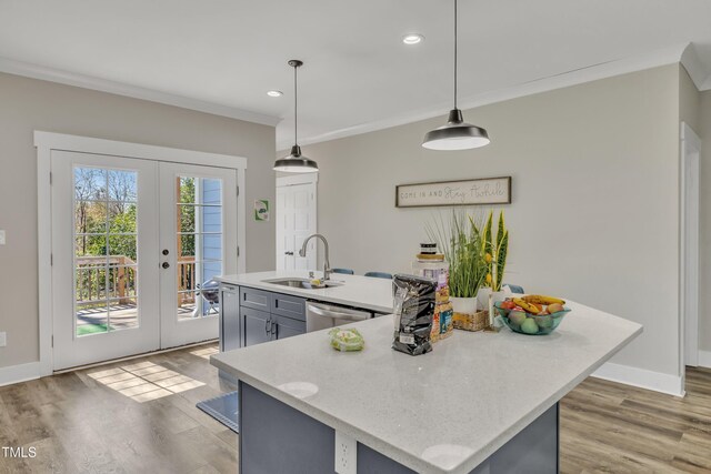 kitchen featuring french doors, stainless steel dishwasher, a sink, and ornamental molding