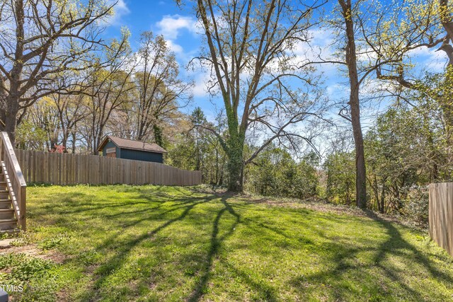 view of yard featuring fence and stairway