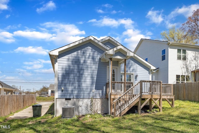 rear view of property with a wooden deck, central air condition unit, stairway, a lawn, and fence