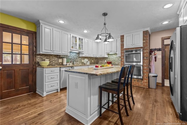 kitchen featuring tasteful backsplash, appliances with stainless steel finishes, a sink, and white cabinets