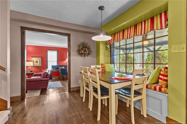 dining space featuring wood finished floors and baseboards