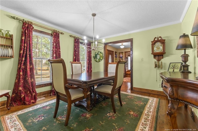 dining space featuring crown molding, baseboards, wood finished floors, and a textured ceiling