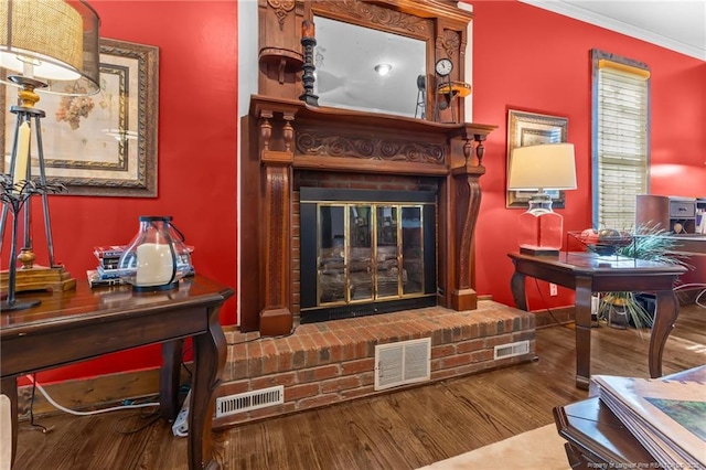living room with ornamental molding, visible vents, and wood finished floors